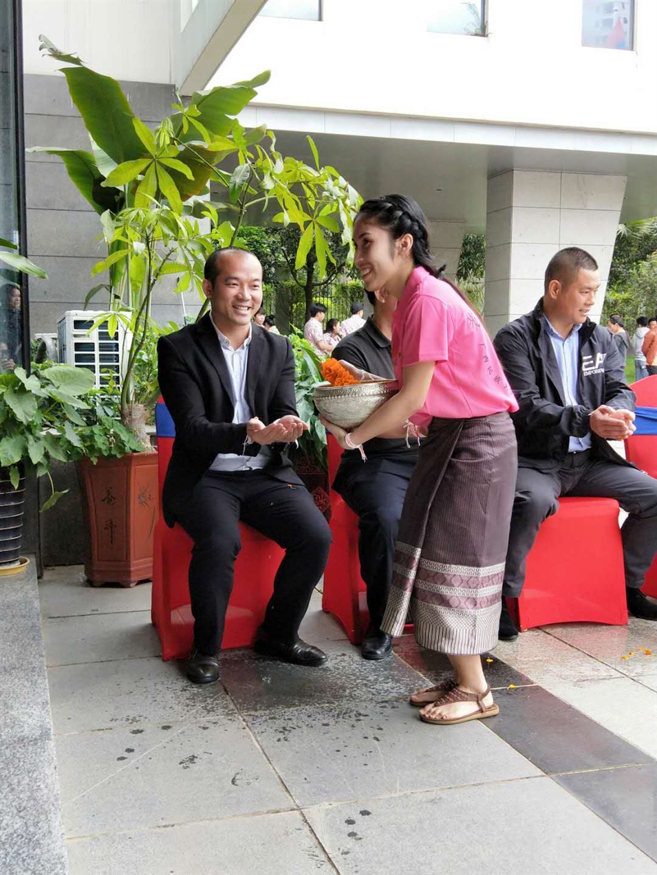 老撾駐廣西留學(xué)生代表將浸有花瓣的香水灑客人的手上，表示對(duì)嘉賓的美好祝福（圖一）